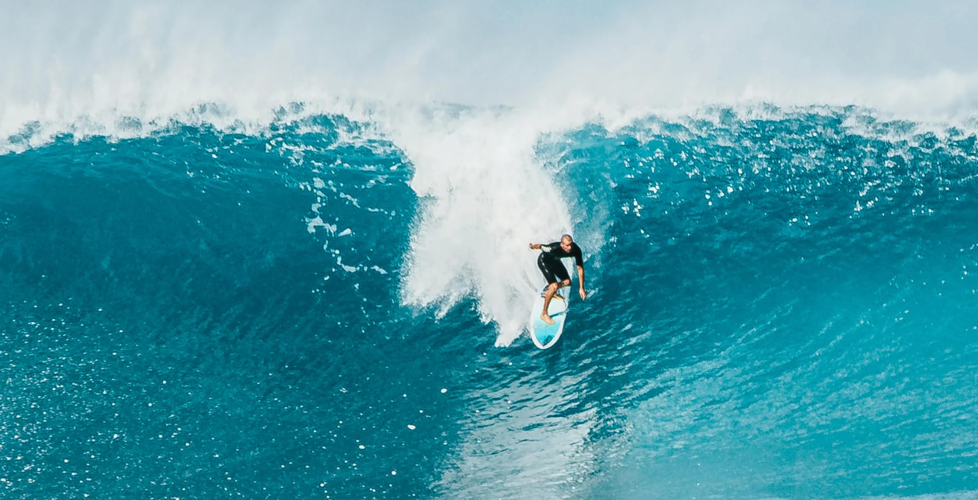 Peselancar yang sedang menunggangi ombak